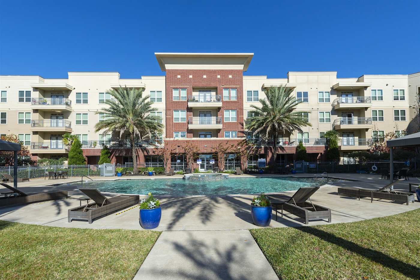 The swimming pool and deck at Regard at Med Center, with the apartment buildings behind