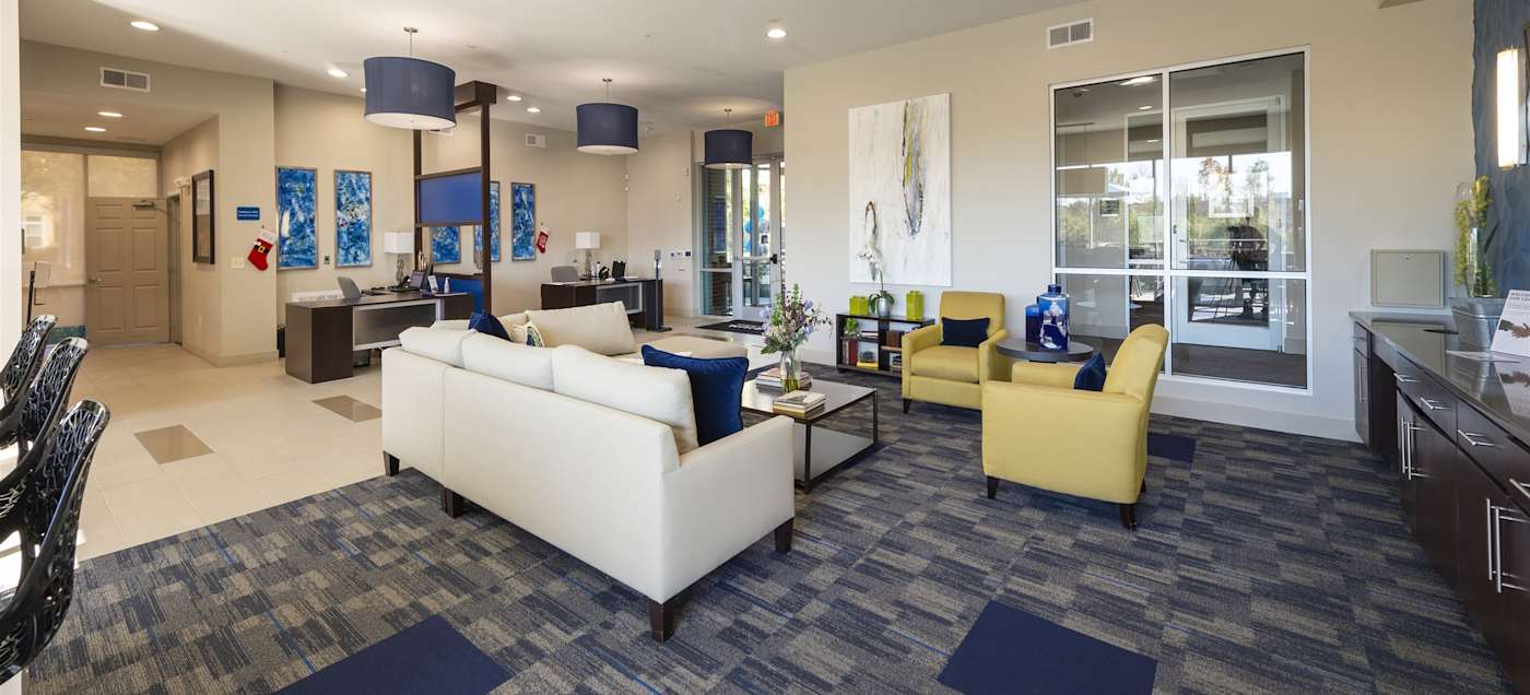 The resident lounge with a white couch and a yellow armchair