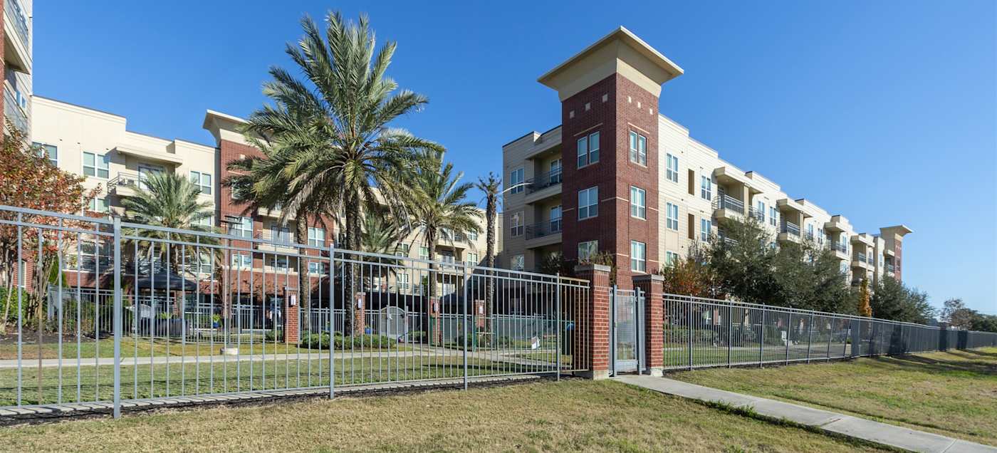The brick tower at the community entrance with the apartment buildings behind