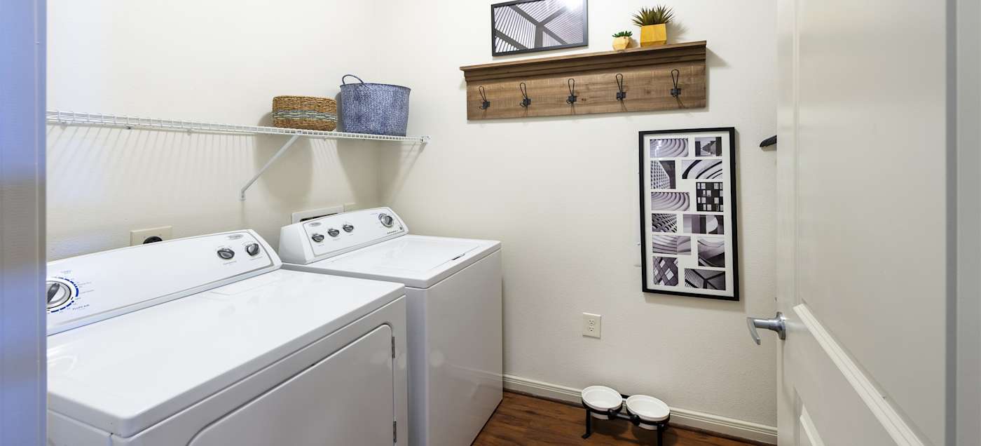 A laundry closet inside the apartment with a full-size washer and dryer
