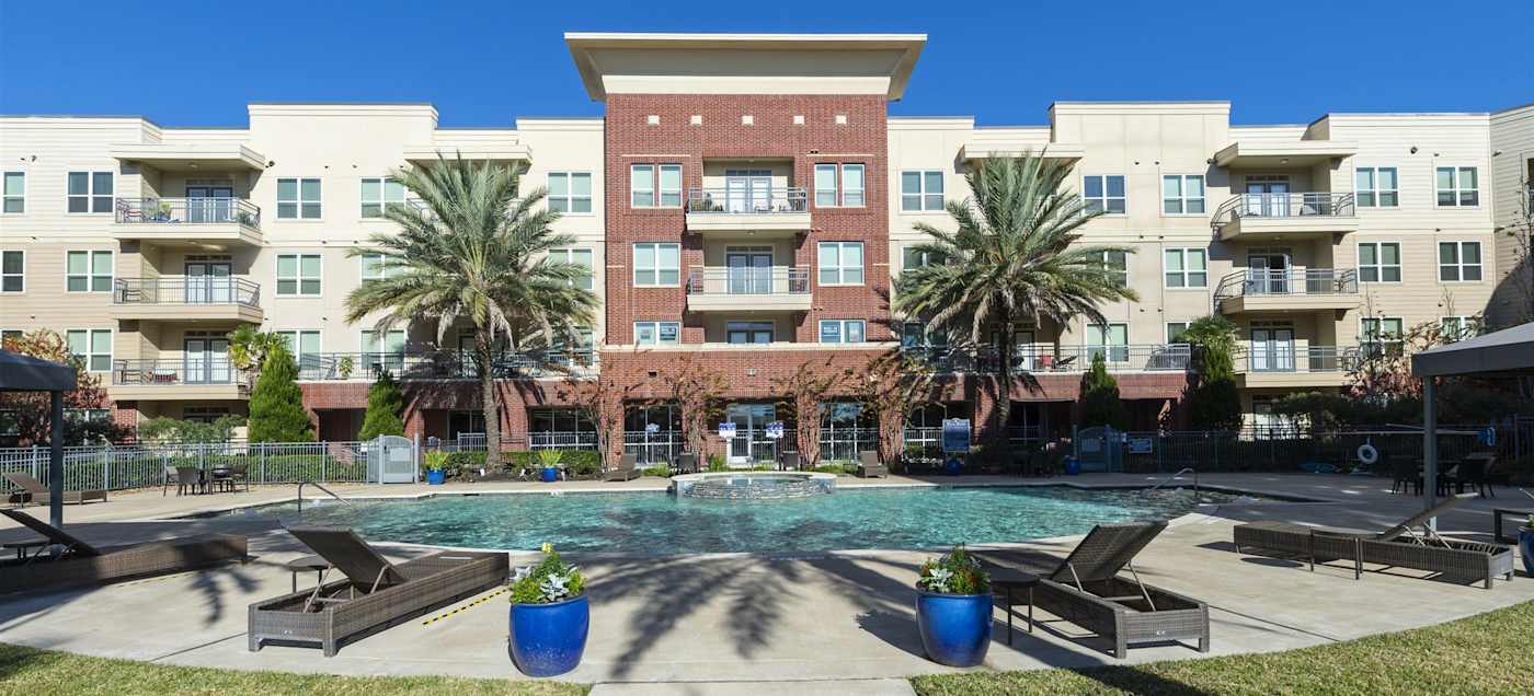 The swimming pool and deck with the apartment buildings behind
