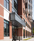 A modern building with a red brick facade and a white entrance.