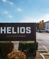 a sign for hellos apartments in front of a parking lot