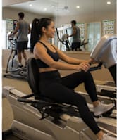 A woman is working out on an exercise bike in a gym.