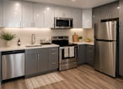 Thumbnail 5 of 10 - A modern kitchen with stainless steel appliances and wooden flooring.