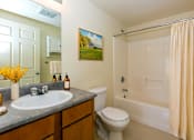 Thumbnail 12 of 19 - A bathroom with a toilet, sink, and bathtub.