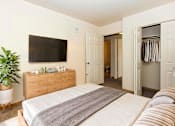 Thumbnail 7 of 19 - A bedroom with a bed, a TV, and a cabinet.