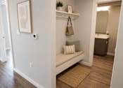 Thumbnail 6 of 10 - A hallway with a bench and a painting on the wall.