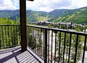 Thumbnail 3 of 10 - A balcony overlooks a valley with houses and trees.