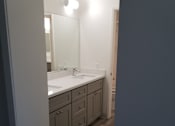 Thumbnail 82 of 82 - A bathroom with a sink, mirror, and cabinets.