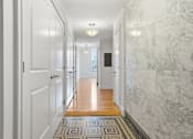 Thumbnail 65 of 74 - A hallway with marble walls and a tiled floor.