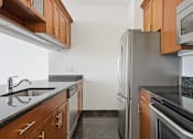 Thumbnail 67 of 74 - A kitchen with a refrigerator, sink, and microwave.