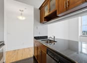 Thumbnail 69 of 74 - A kitchen with wooden cabinets and black appliances.