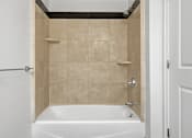 Thumbnail 71 of 74 - A white bathtub with a shower head and a shower curtain rod.