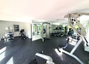 Thumbnail 8 of 9 - A gym with a variety of equipment including a treadmill, weights, and a bench press.