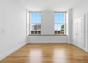 Thumbnail 64 of 74 - A room with wooden floors and two windows.