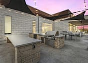 Thumbnail 5 of 39 - Resident outdoor patio area with a grill and a table with chairs at LynnCora, Grand Prairie