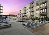 Thumbnail 1 of 39 - pool with lounge chairs in front of an apartment building at LynnCora, Texas