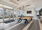 Thumbnail 16 of 39 - a ping pong table in a game room with glass doors at LynnCora, Texas, 75052