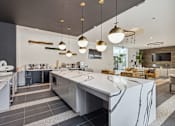Thumbnail 18 of 39 - a kitchen with a large island and a dining room with chairs at LynnCora, Grand Prairie, 75052