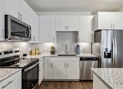 Thumbnail 21 of 39 - Model apartment kitchen area with stainless steel applicances at LynnCora, Grand Prairie