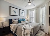 Thumbnail 24 of 39 - a bedroom with a large bed and a ceiling fan at LynnCora, Grand Prairie, Texas