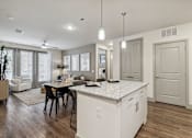 Thumbnail 31 of 39 - an open kitchen and dining room with a table and chairs and kitchen island at LynnCora, Texas, 75052
