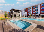 Thumbnail 7 of 18 - A swimming pool with Amara apartment building in the backgroundwith a red and white facade.