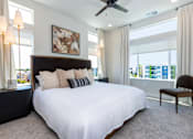 Thumbnail 3 of 18 - A bedroom with a large bed and a ceiling fan.