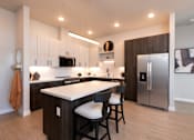 Thumbnail 1 of 18 - A modern kitchen with a white countertop and stainless steel appliances.