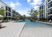 Thumbnail 2 of 79 - a large swimming pool in courtyard with Mira at Palmer Ranch Apartment buildings around it at Mira at Palmer Ranch in Sarasota, FL