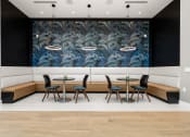 Thumbnail 35 of 79 - resident lounge with tables and chairs and a large mural on the wall at Mira at Palmer Ranch in Sarasota, FL