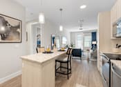 Thumbnail 68 of 79 - an open kitchen and dining area with a large island and a living room at Mira at Palmer Ranch, Sarasota, FL