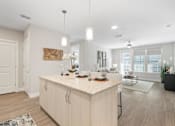Thumbnail 47 of 79 - a kitchen with a large island open to a living room with large windows at Mira at Palmer Ranch, Sarasota