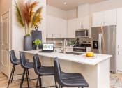 Thumbnail 2 of 25 - model apartment kitchen area with  large island counter and stainless steel appliances at Solasta, Sacramento, CA, 95831