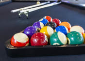 Thumbnail 12 of 23 - a game of billiards on a pool table at Zeta Luxury Apartments in Sacramento, CA