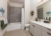 Thumbnail 6 of 23 - Bathroom area with mirrored vanity and shower/bath area at Zeta Luxury Apartments in Sacramento, CA