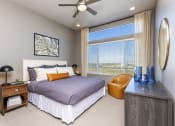 Thumbnail 3 of 23 - apartment bedroom has a large window and lighted ceiling fan at Zeta Luxury Apartments in Sacramento, CA