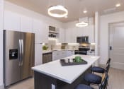 Thumbnail 5 of 23 - a kitchen with stainless steel appliances and quartz counter tops at Zeta Luxury Apartments in Sacramento, CA