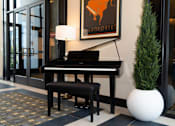 Thumbnail 12 of 18 - A piano and stool in resident lounge at Amara