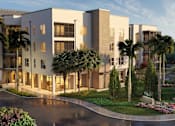 Thumbnail 3 of 15 - A modern building with a driveway and palm trees in front.