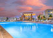 Thumbnail 9 of 25 - apartments swimming pool lounge area with apartment buildings in background at twilight at Solasta, Sacramento, CA, 95831
