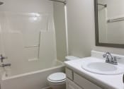Thumbnail 10 of 10 - A bathroom with a sink toilet and bathtub.