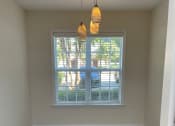 Thumbnail 8 of 10 - A breakfast nook with three hanging lights and a large window.