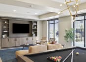 Thumbnail 11 of 29 - a living room with a pool table and a tv