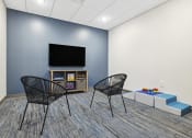 Thumbnail 23 of 29 - a room with two chairs and a table with a television on top of it