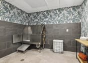 Thumbnail 26 of 29 - a large stainless steel bathtub in a large bathroom with a tropical wallpaper on the wall