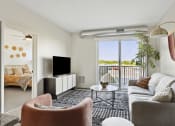 Thumbnail 7 of 29 - a spacious living room with a sliding glass door leading to a balcony with a view of the