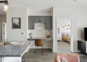 Thumbnail 5 of 29 - a kitchen with a breakfast bar and a bedroom in the background