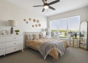 Thumbnail 8 of 29 - a bedroom with a large window and a ceiling fan